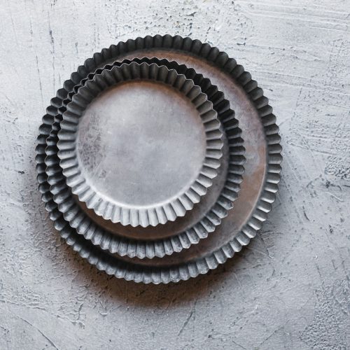 Three metal quiche pans stacked.